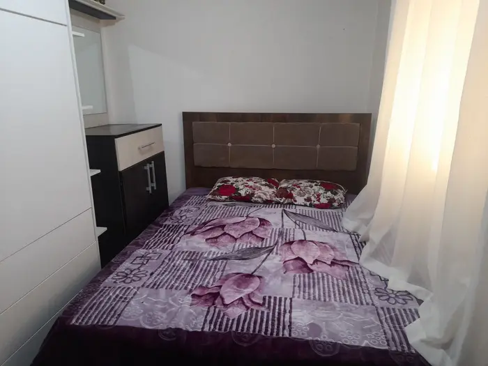 کلبه یک خوابه هیراد - اتاق خواب  باتخت خواب دونفره و پنجره روبه جاده بین درختان رد شده و کوه جنگل